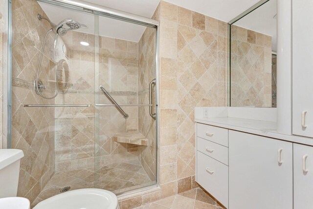 bathroom featuring toilet, a stall shower, and vanity