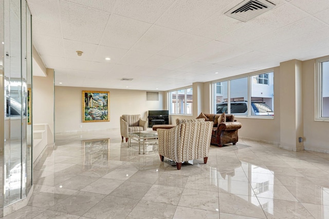 living area with baseboards, visible vents, and marble finish floor