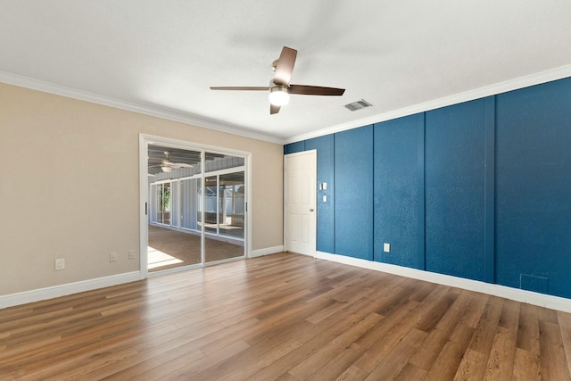 unfurnished room featuring visible vents, wood finished floors, a ceiling fan, and ornamental molding