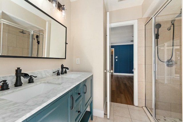 bathroom featuring tile patterned flooring, a shower stall, and a sink