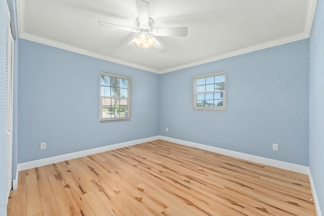 empty room featuring plenty of natural light, wood finished floors, and ornamental molding