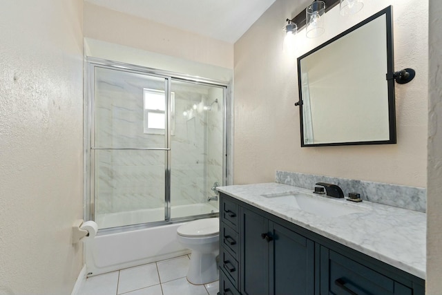 full bathroom with vanity, shower / bath combination with glass door, tile patterned floors, toilet, and a textured wall