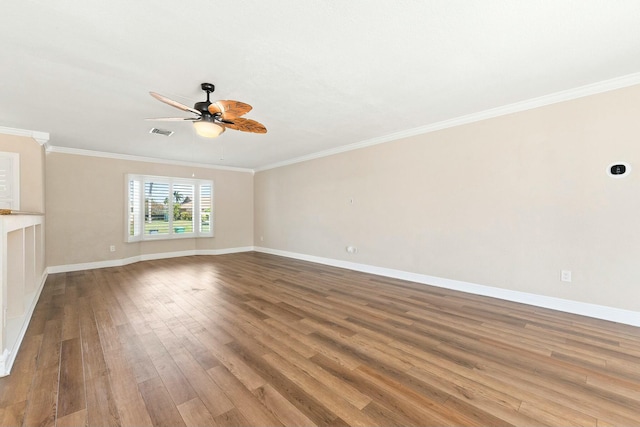 empty room with visible vents, crown molding, baseboards, and wood finished floors