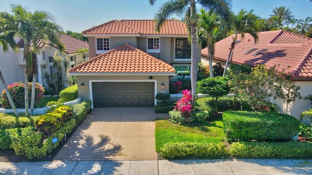 mediterranean / spanish-style house with stucco siding, a tiled roof, and a garage