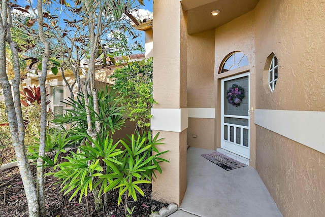 entrance to property featuring stucco siding