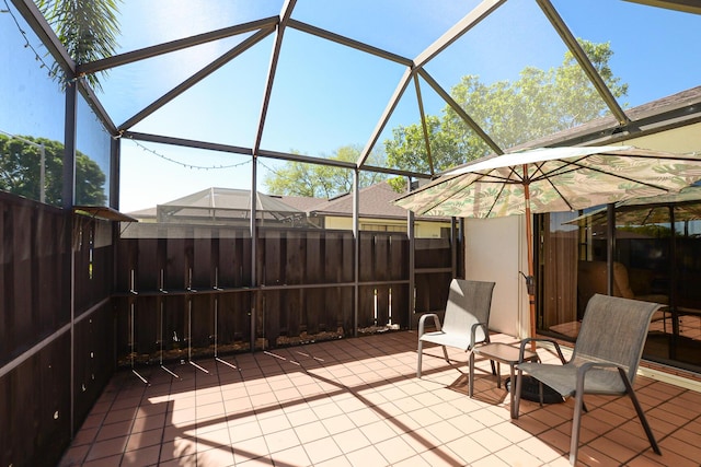 view of patio with glass enclosure and fence