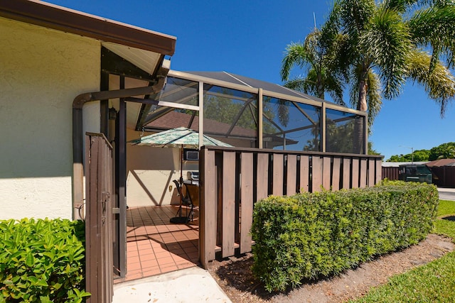 view of home's exterior with stucco siding and glass enclosure