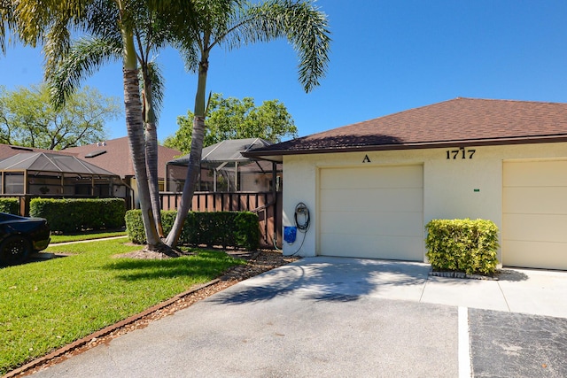 exterior space featuring stucco siding, a garage, a lanai, and a front lawn