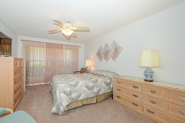 bedroom with light colored carpet, a ceiling fan, and a textured ceiling