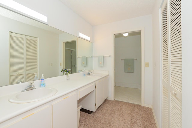 bathroom with double vanity, a closet, and a sink