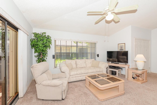 carpeted living area featuring a textured ceiling, ceiling fan, and vaulted ceiling