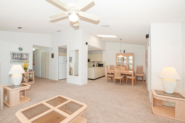 living area with light carpet and vaulted ceiling