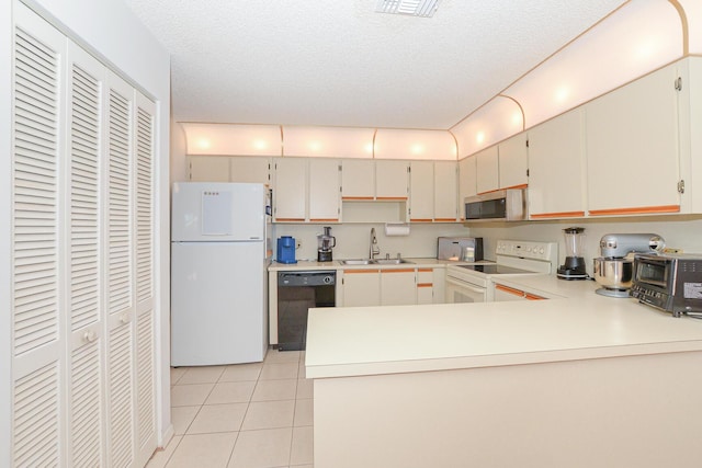 kitchen with a sink, white appliances, light tile patterned flooring, and light countertops