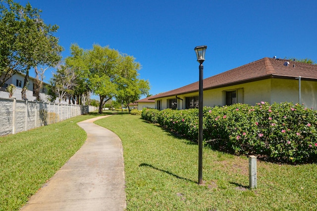 view of property's community with a yard and fence