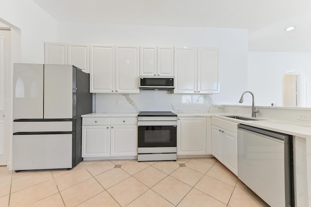 kitchen with a sink, white appliances, light tile patterned floors, and light countertops