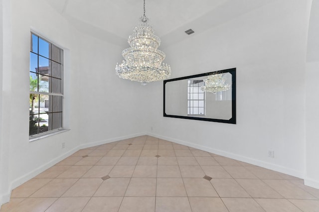 spare room with visible vents, baseboards, and an inviting chandelier