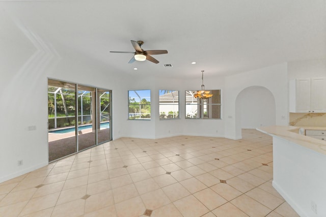 interior space with visible vents, baseboards, recessed lighting, ceiling fan with notable chandelier, and arched walkways