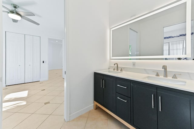 bathroom featuring tile patterned flooring, double vanity, ceiling fan, and a sink