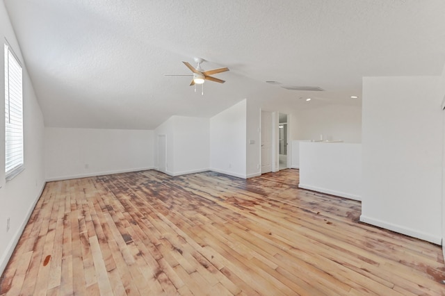 bonus room featuring lofted ceiling, a textured ceiling, and hardwood / wood-style flooring