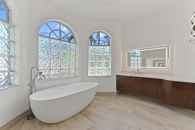 bathroom featuring a freestanding tub, marble finish floor, and vanity