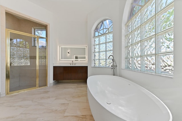 bathroom featuring vanity, a soaking tub, marble finish floor, and a shower stall