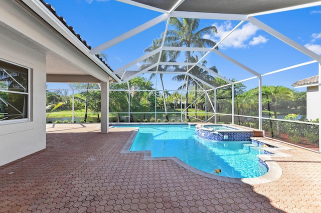 view of swimming pool with a patio, a pool with connected hot tub, and a lanai