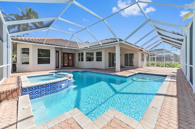 view of pool featuring glass enclosure, a pool with connected hot tub, ceiling fan, french doors, and a patio area