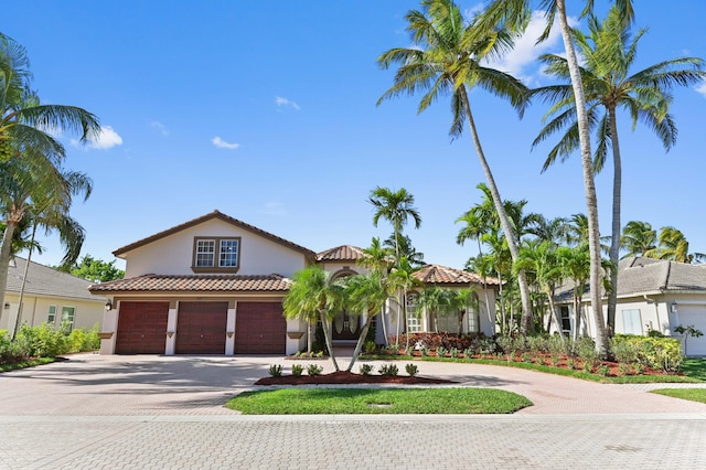 mediterranean / spanish house featuring stucco siding and decorative driveway