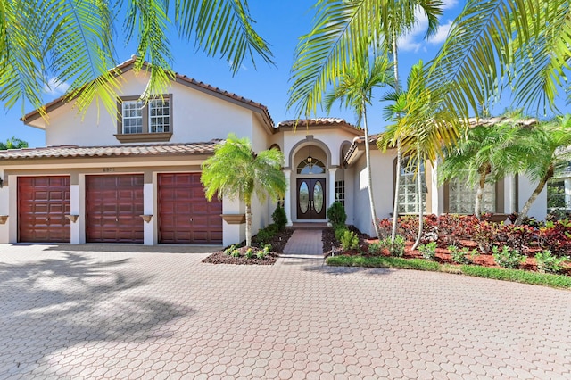 mediterranean / spanish home featuring stucco siding and decorative driveway