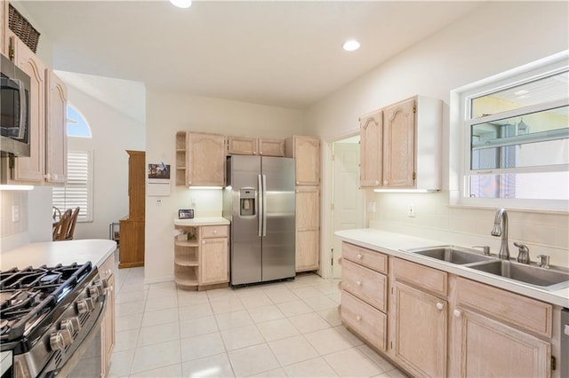 kitchen featuring light brown cabinets, open shelves, a sink, decorative backsplash, and appliances with stainless steel finishes