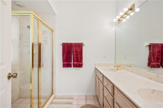 bathroom with tile patterned floors, a stall shower, and a sink