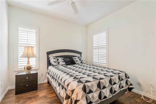 bedroom featuring multiple windows, ceiling fan, baseboards, and wood finished floors