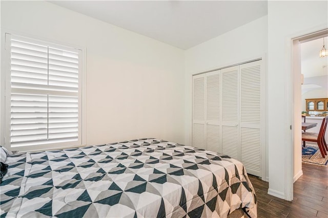 bedroom with a closet, arched walkways, and wood finished floors