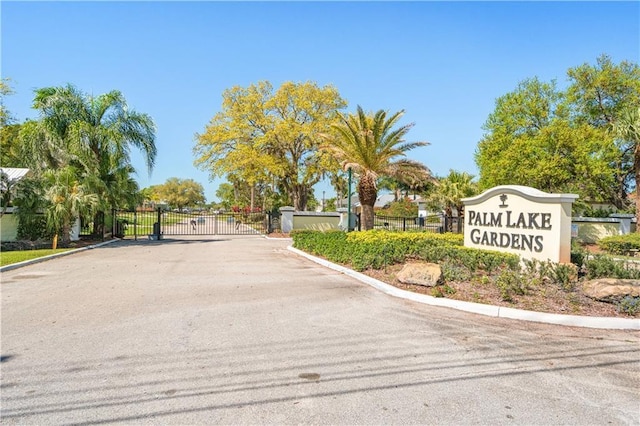 view of street with a gate, curbs, and a gated entry