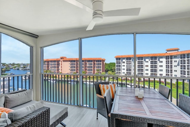 sunroom featuring a water view, plenty of natural light, and ceiling fan