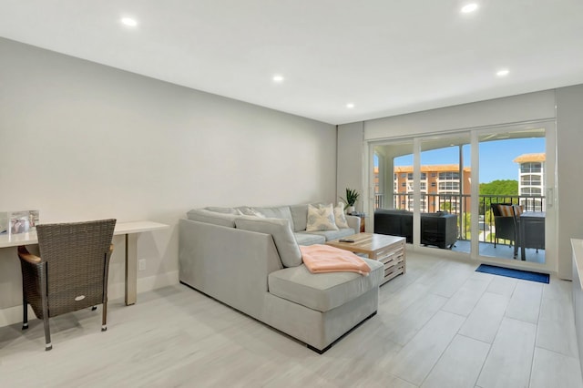 living room featuring recessed lighting, light wood-style flooring, and baseboards