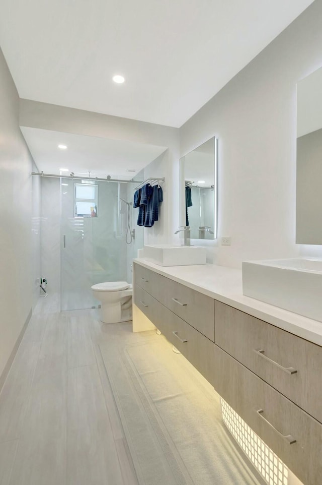 full bathroom featuring vanity, toilet, recessed lighting, and a marble finish shower