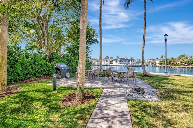 view of yard with a water view, a fire pit, and a patio area