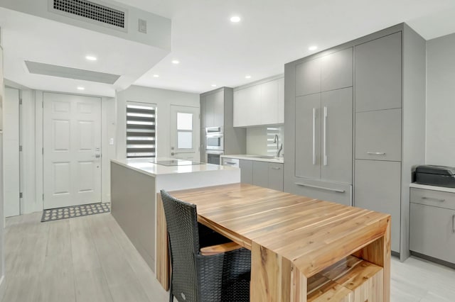 kitchen with visible vents, gray cabinetry, modern cabinets, and a sink