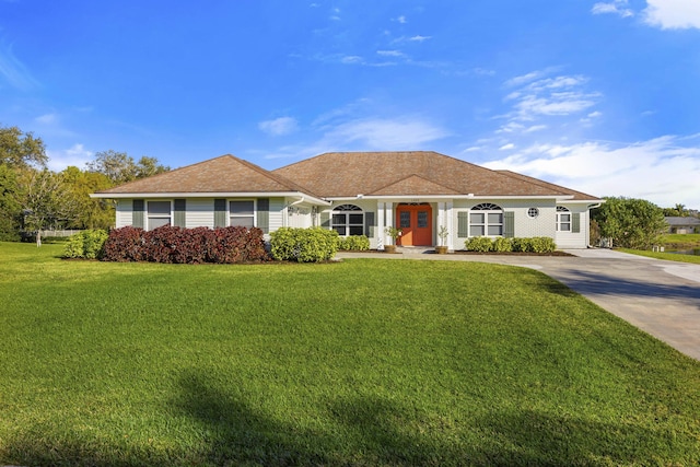 ranch-style home featuring concrete driveway and a front lawn