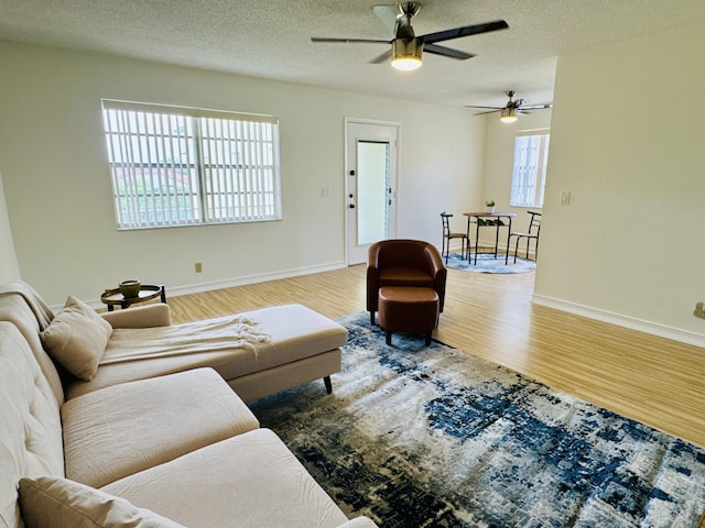 230 Normandy Ln E, Delray Beach, FL 33484 - living room with wood finished floors, ceiling fan, baseboards, and a textured ceiling