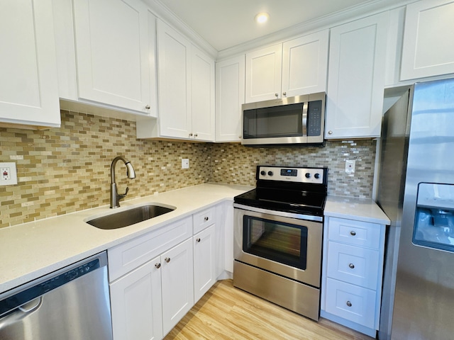 230 Normandy Ln E, Delray Beach, FL 33484 - kitchen featuring stainless steel appliances, a sink, light countertops, white cabinets, and backsplash
