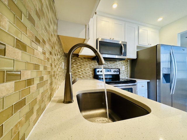 230 Normandy Ln E, Delray Beach, FL 33484 - kitchen with stainless steel appliances, white cabinets, backsplash, light stone countertops, and recessed lighting