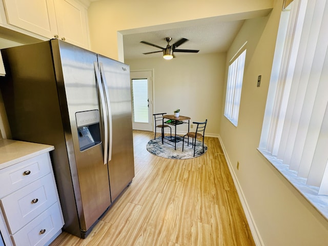 230 Normandy Ln E, Delray Beach, FL 33484 - kitchen featuring stainless steel fridge with ice dispenser, light wood-type flooring, white cabinets, a ceiling fan, and light countertops