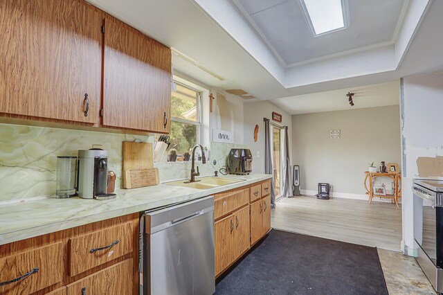 kitchen featuring stainless steel dishwasher, light countertops, a sink, and washer and clothes dryer