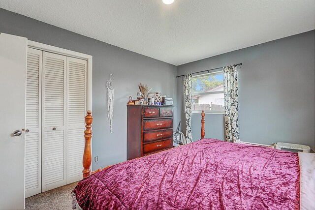 bedroom with a textured ceiling, baseboards, and carpet floors