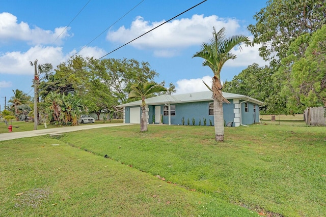 view of front of home featuring driveway, a front lawn, and an attached garage