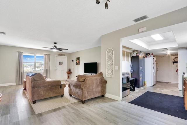 kitchen featuring visible vents, light countertops, light wood-style floors, stainless steel dishwasher, and backsplash