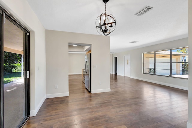 interior space with a notable chandelier, dark wood-style floors, visible vents, and a wealth of natural light