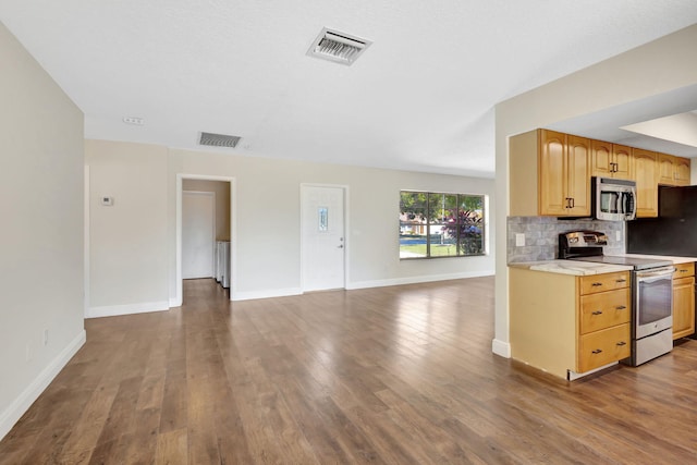 kitchen featuring visible vents, stainless steel appliances, dark wood-type flooring, open floor plan, and backsplash